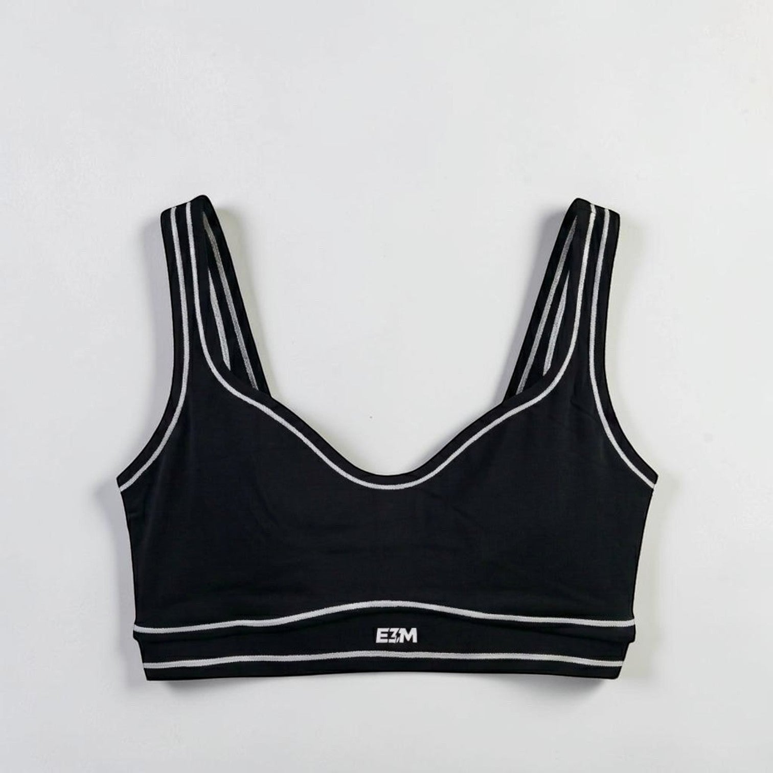 E3M Pre-workout black performance sports bra with white striped trim and logo detail, made from moisture-wicking fabric.