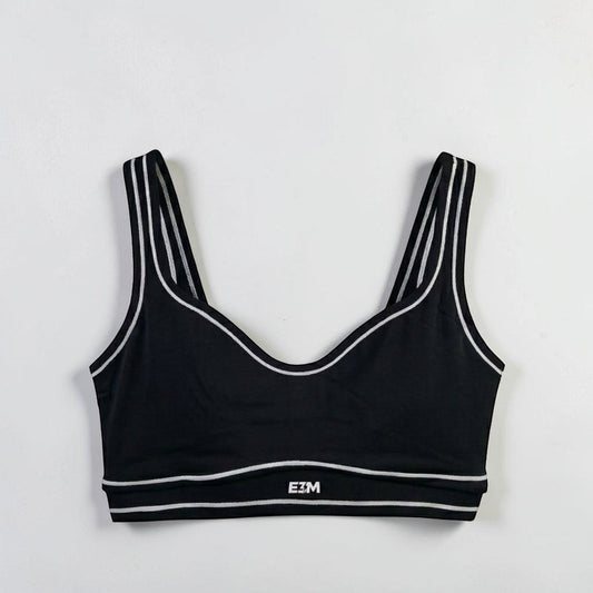E3M Pre-workout black performance sports bra with white striped trim and logo detail, made from moisture-wicking fabric.